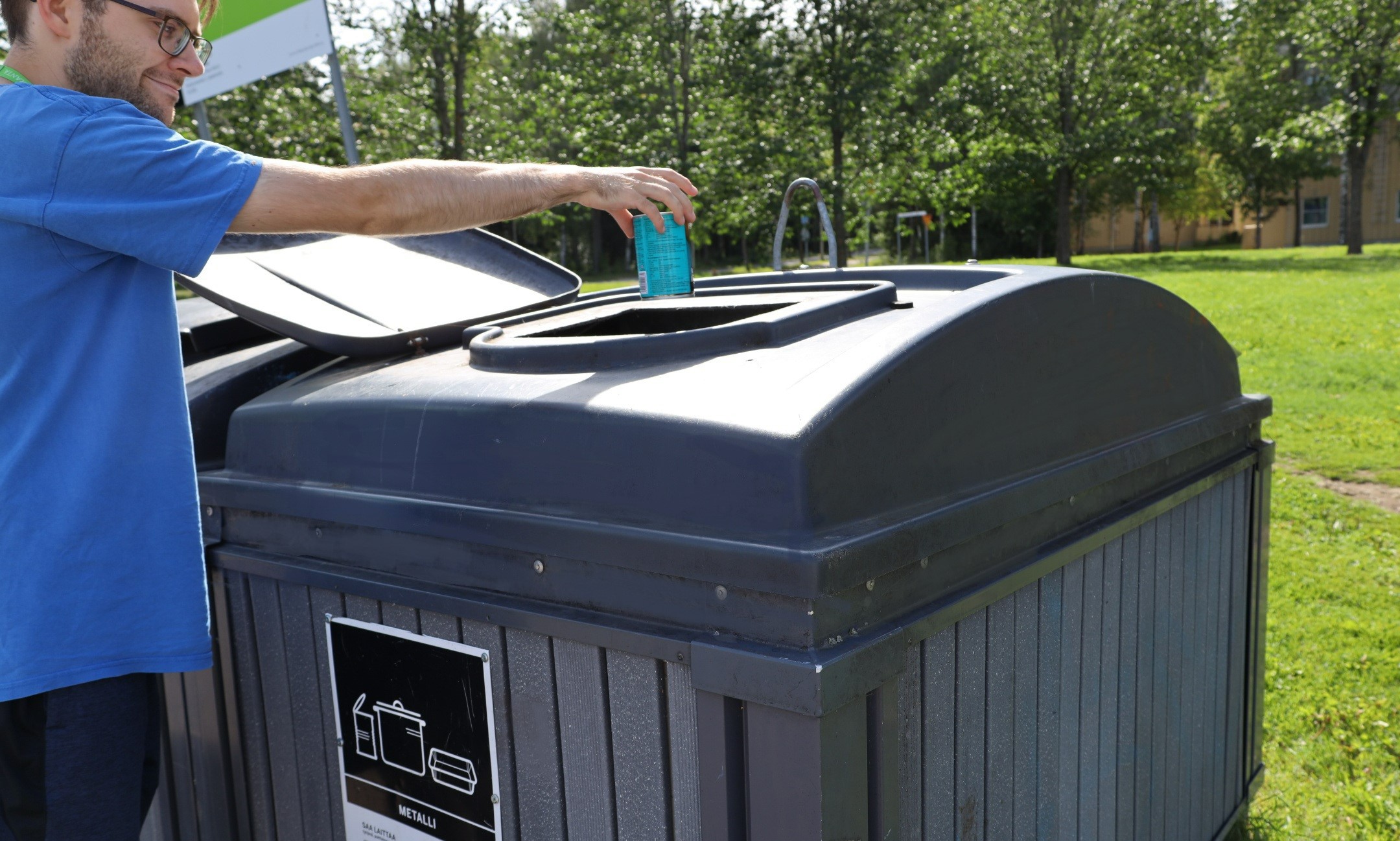 A person recycling a metal can.