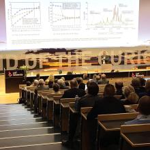 A speaker having a presentation in a conference auditorium.